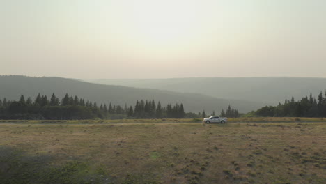 white pickup truck off road driving through vast outdoor landscape, saskatchewan canada