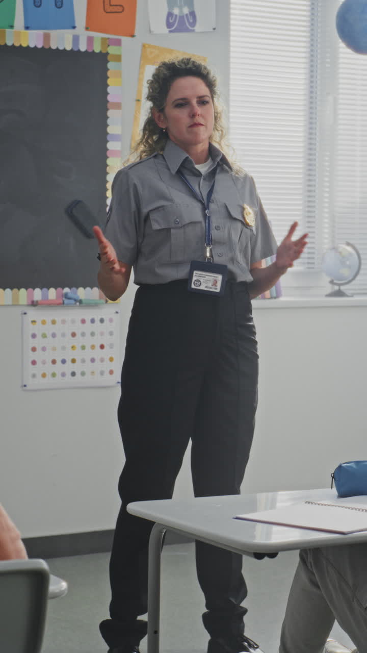 American Female Policewoman Visiting Primary School Classroom Teaching Children About Discipline and