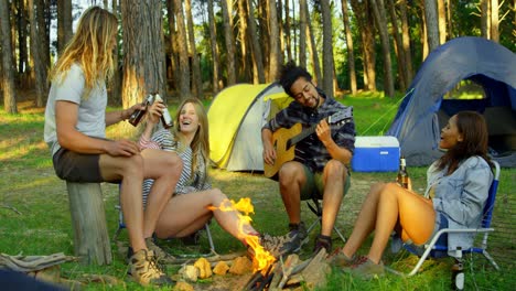 friends having fun near bonfire in the forest 4k