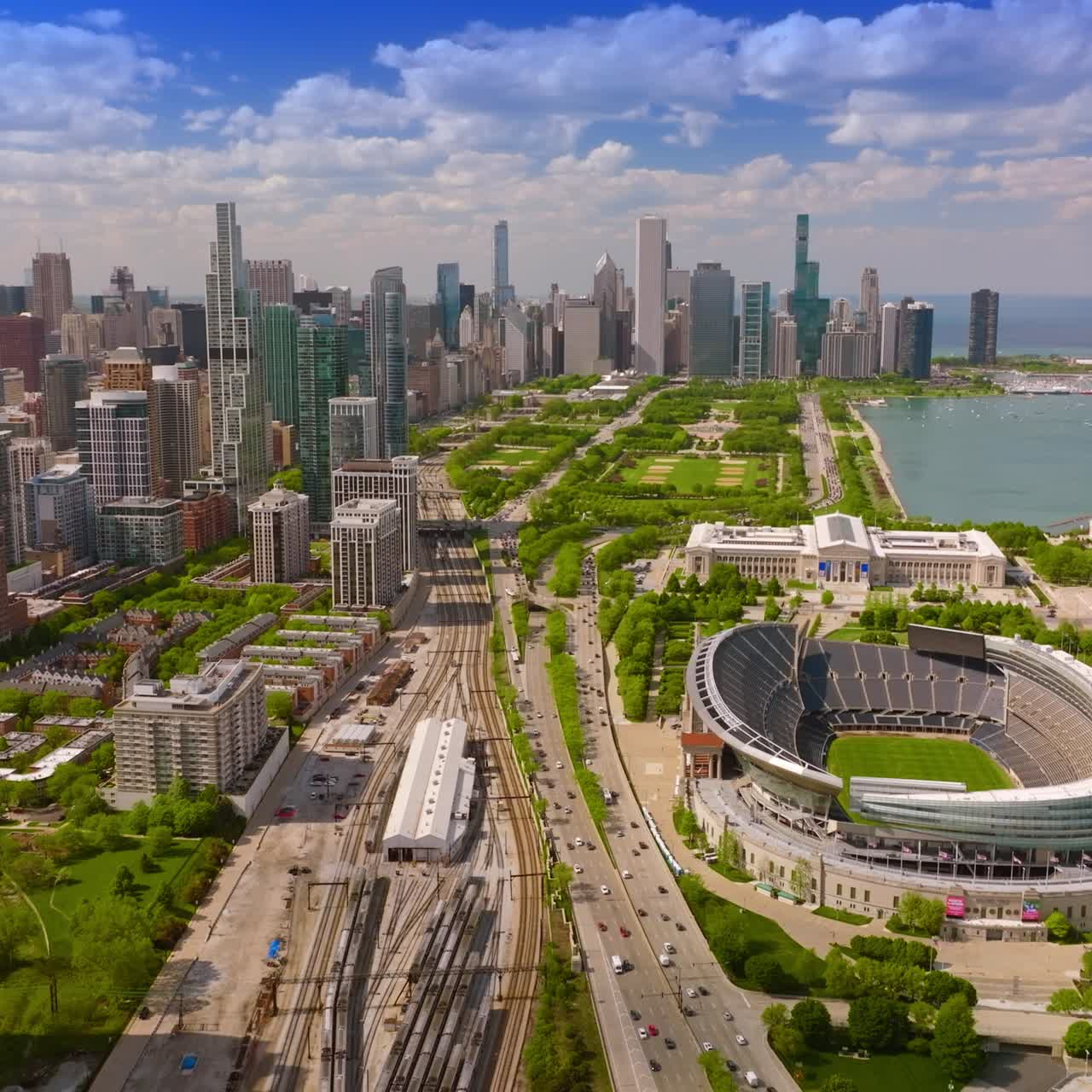 Lo stadio Soldier Field nel parco del centro di Chicago. Skyline della metropoli sullo sfondo di un cielo estivo blu e nuvoloso