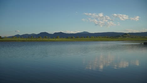 time lapse of clouds floating over rolling hills and water