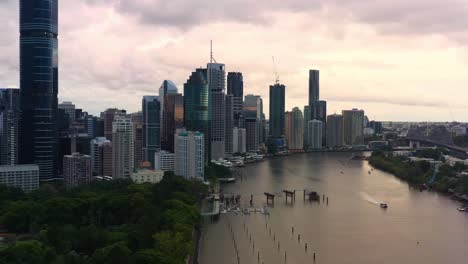 Panoramic-view-drone-flyover-Brisbane-river-capturing-iconic-story-bridge,-Kangaroo-point-and-riverside-downtown-cityscape-of-Central-business-district,-capital-city-of-Queensland,-Australia