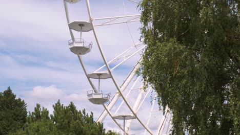 Close-up-views-of-a-Ferris-wheel-rotating-against-a-blue-sky-with-some-clouds