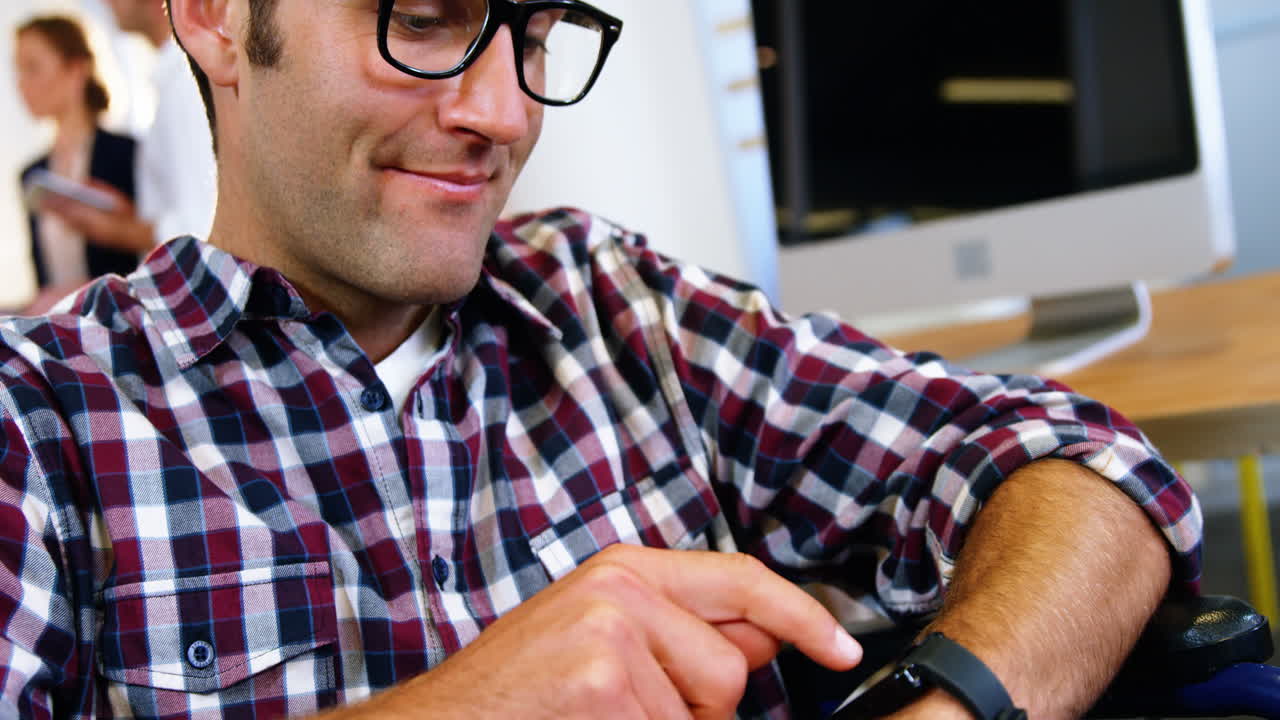 un hombre de negocios sonriente usando su reloj inteligente.