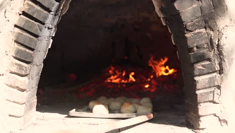 Brot-Backen-Im-Lehmofen,-Traditionelle-Bäckerei-Mit-Gebäck-In-Zeitlupe