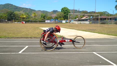 un niño con discapacidad conduciendo un handbike en una carrera de paraciclismo, esforzándose por ganar