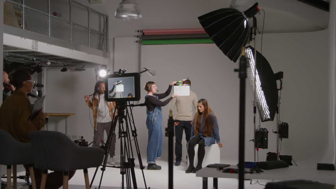 asistente femenina utiliza clapperboard como actores filmar película o video en el estudio con el equipo de filmación y el director filmado en tiempo real