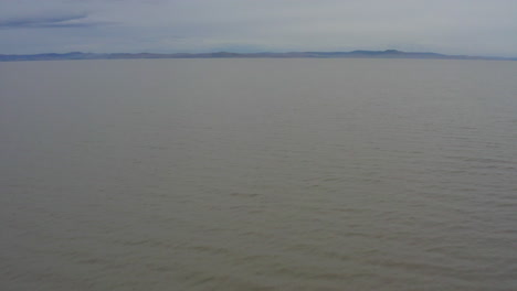 drone flying low over the water at lake george, canberra act