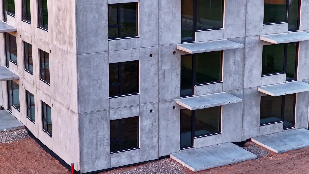 Facciata in cemento grezzo di un edificio residenziale di nuova costruzione in cantiere.