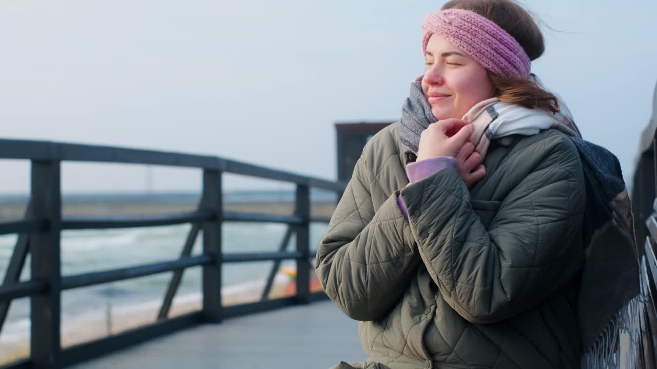 Woman enjoying the cold weather by the seaside