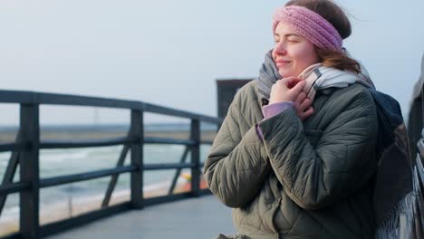 woman enjoying the cold weather by the seaside