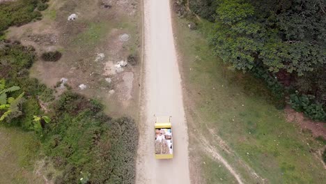 vista aérea de pájaros de un camión amarillo que entrega alimentos y bebidas en los distritos remotos de timor-leste en el sureste de asia