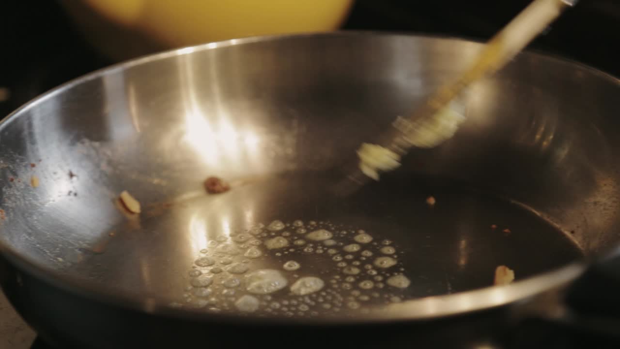 Spreading The Butter Into The Hot Skillet And Stirring Until It Melts Completely - Close Up Shot