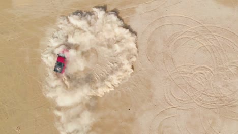 red truck drifting in the desert sand, aerial top view