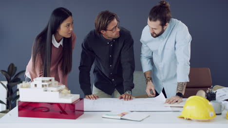 tres jóvenes arquitectos trabajando juntos a escala