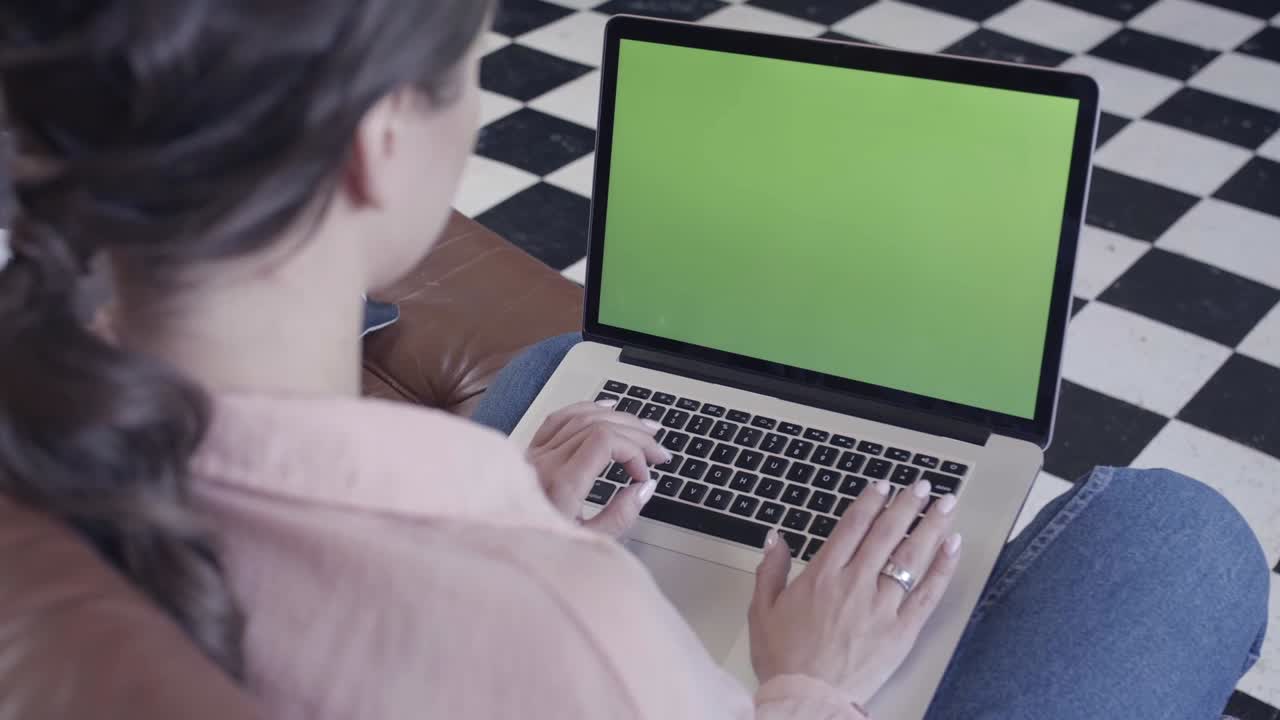 mujer trabajando en una computadora portátil con pantalla verde