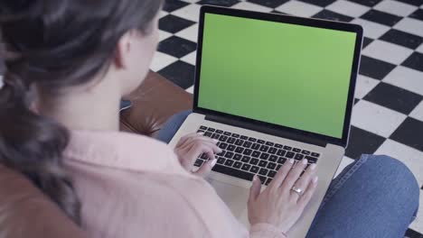 woman working on a laptop with green screen