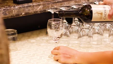 wine being poured into a glass at bar