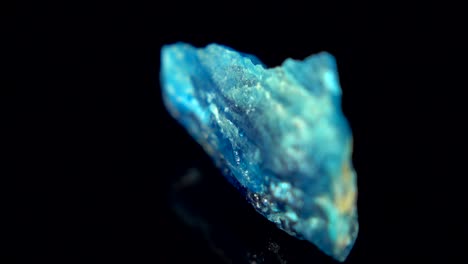 rotación sin problemas de un mineral azul agua (apatita azul) frente a un fondo negro