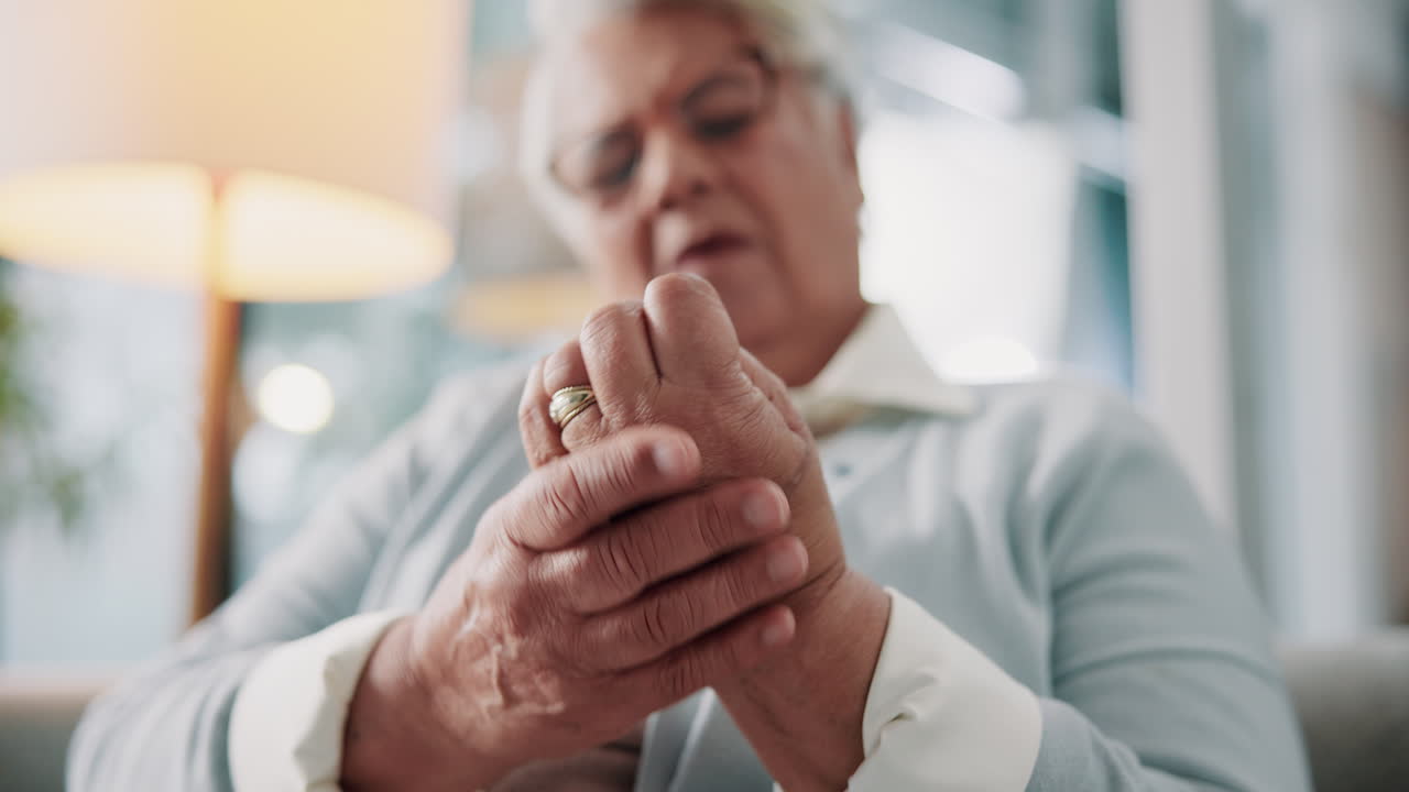 Donna anziana che prova dolore alla mano a causa dell'artrite