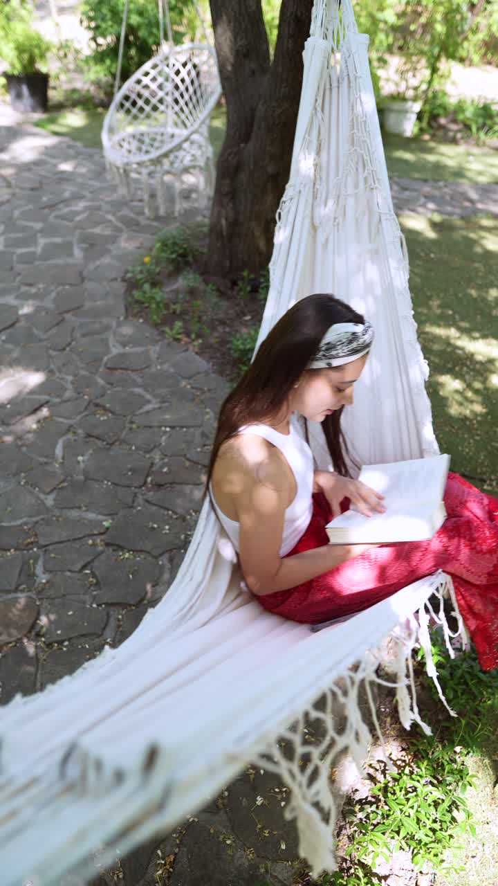 mujer leyendo en una hamaca en un jardín