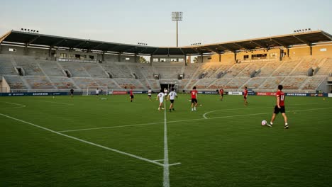 an open football field during training: players practicing in a spacious stadium under the evening sky, highlighting team dynamics and skill development