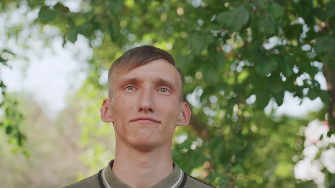 Man Looks Upward, Person Wearing Spectacles Peers Through Leaves, Man Wearing Glasses Observes Luminous Canopy Overhead, Man With Spectacles Lifts His Eyes Towards Bright Sky Above Verdant Trees