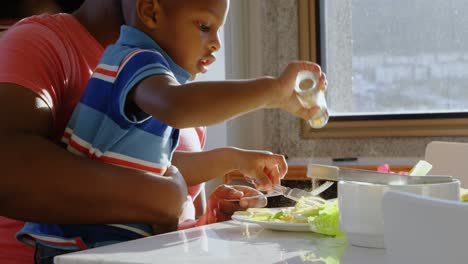 padre e hijo comiendo en la mesa del comedor en casa 4k
