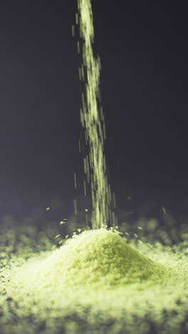 vertical video of close up of heap of green sand grains and copy space on black background