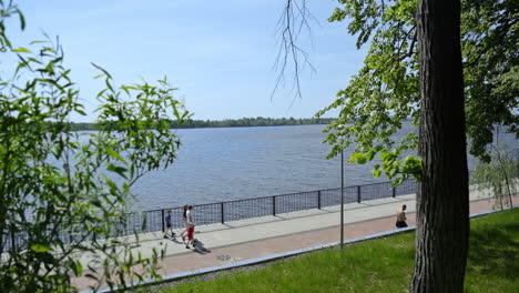 park and river scene with people walking