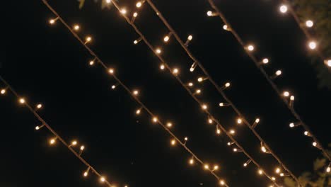 rows of glowing string lights illuminate the dark evening sky
