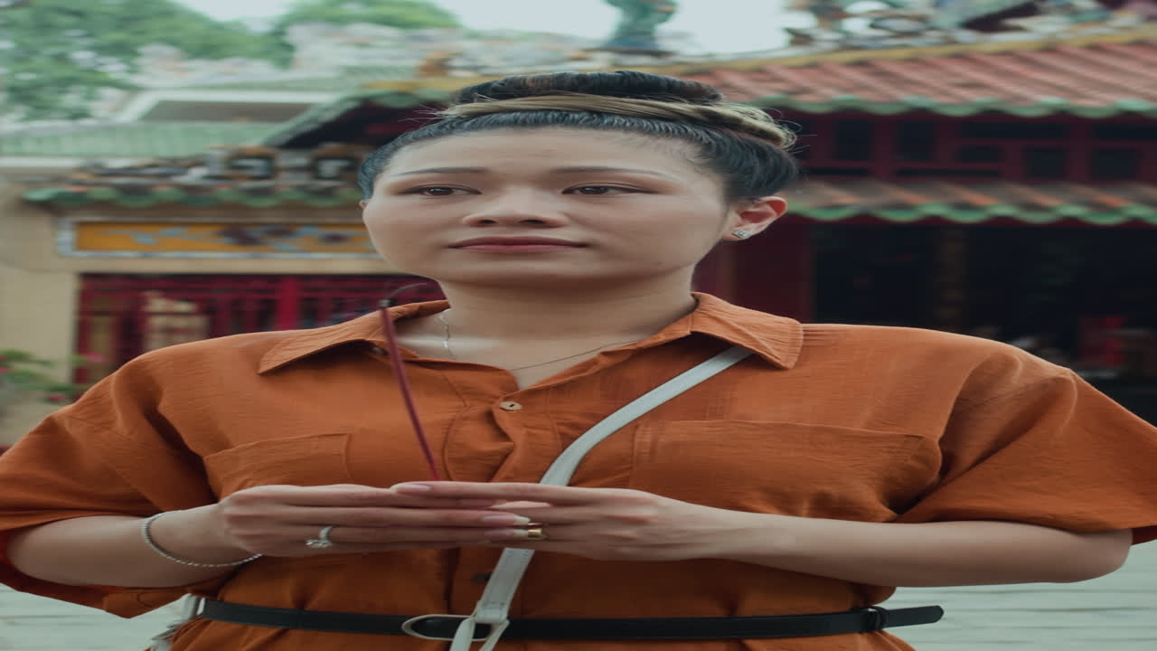 Portrait of Woman Praying with Candle Outside Temple