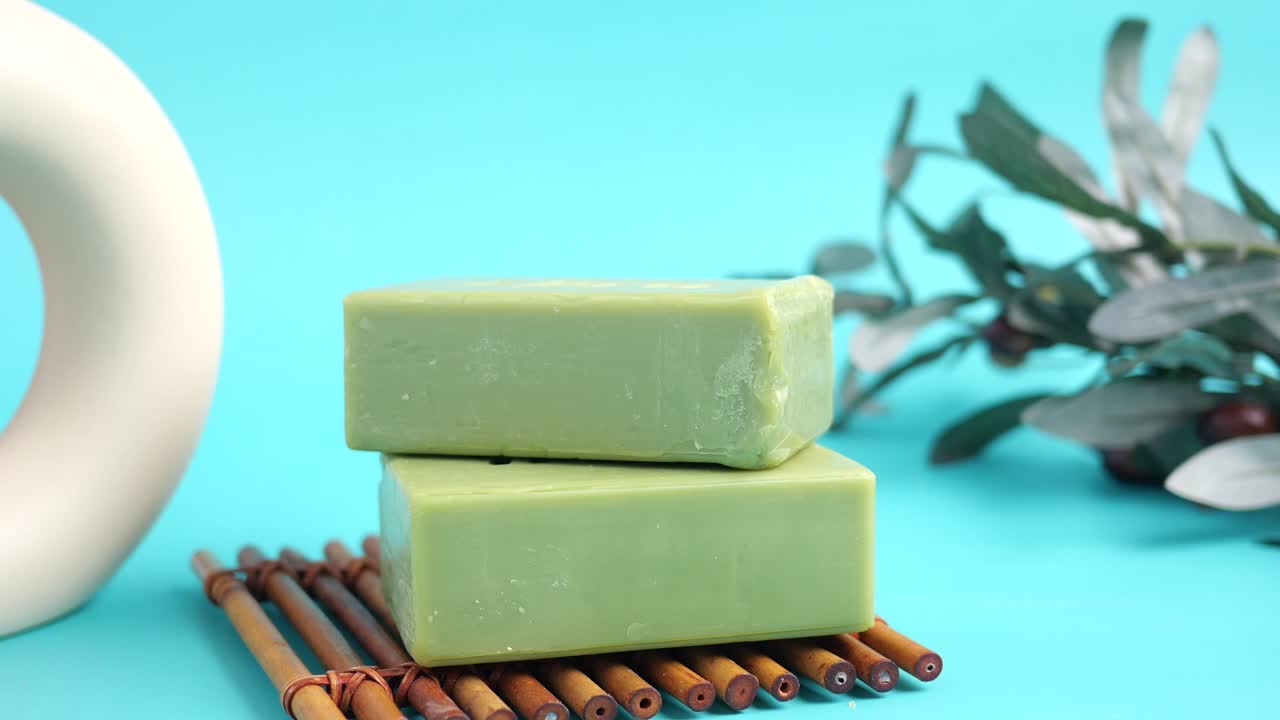 Mano che prende una saponetta verde da una pila