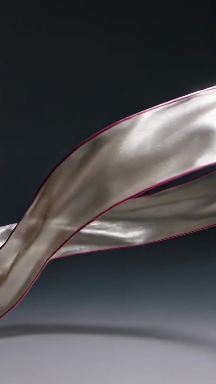 Video verticale: Nastro di raso che fluttua e si attorciglia nello studio, mosso dal flusso d'aria per mostrare la sua lucentezza.