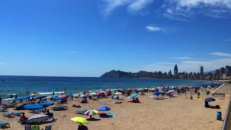 Famosa-Playa-En-Benidorm,-España-Durante-El-Día-Cerca-Del-Mar-Balear-Llena-De-Tumbonas-En-Temporada-Alta-4k-30-Fps