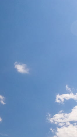 sun lighting the cirrus clouds in the azure skies. big grey cloud appears and covers the sky. low angle view. timelapse. vertical video