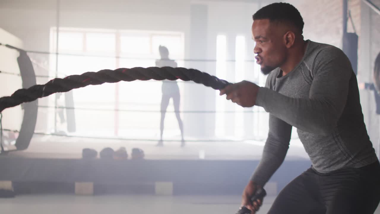 Video of fit african american man training with rope at gym
