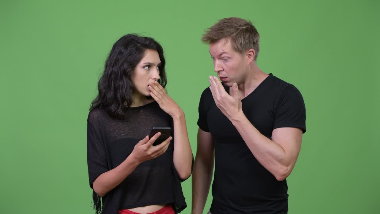 una pareja joven usando el teléfono juntos.