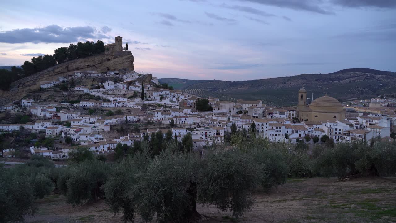 Splendida vista su un villaggio rurale spagnolo con case bianche e una chiesa su una collina al tramonto