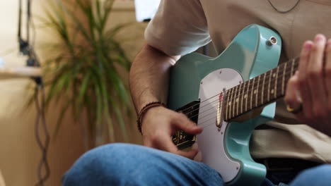 young man practising with the guitar