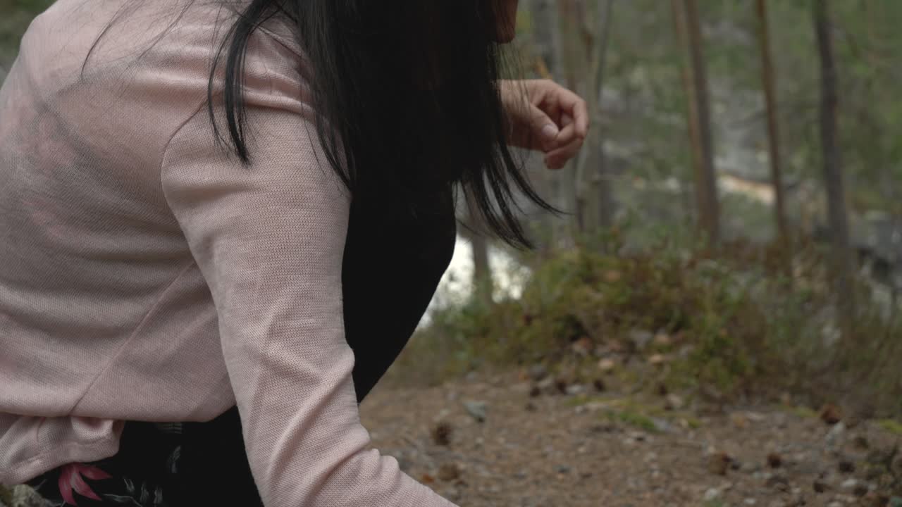 소녀는 숲에서 무언가를 가지고 노는