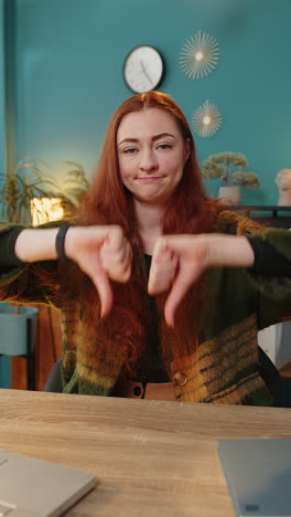 upset business woman freelancer working on laptop showing thumbs down sign disapproval dissatisfied