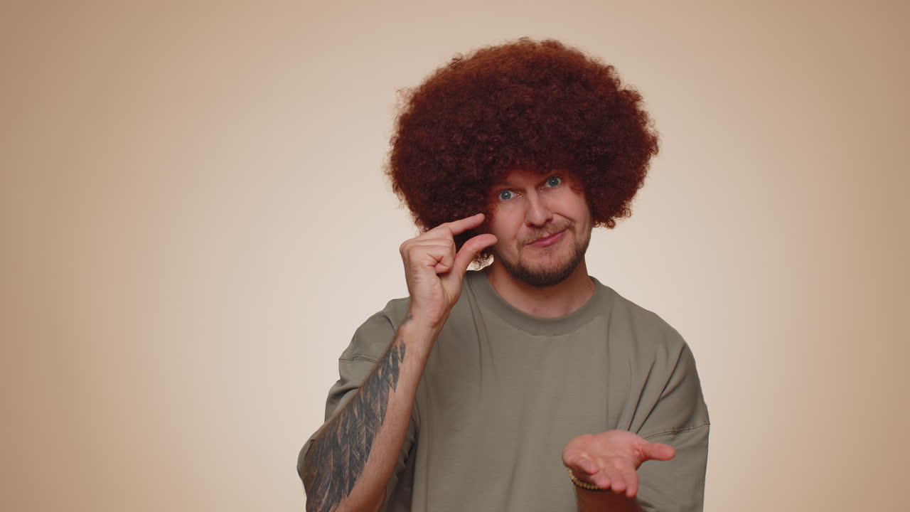 hombre mostrando un pequeño gesto con una sonrisa escéptica, mostrando un signo mínimo, midiendo tamaño pequeño