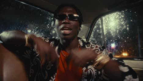 african american musician rapping at camera during car ride in night city