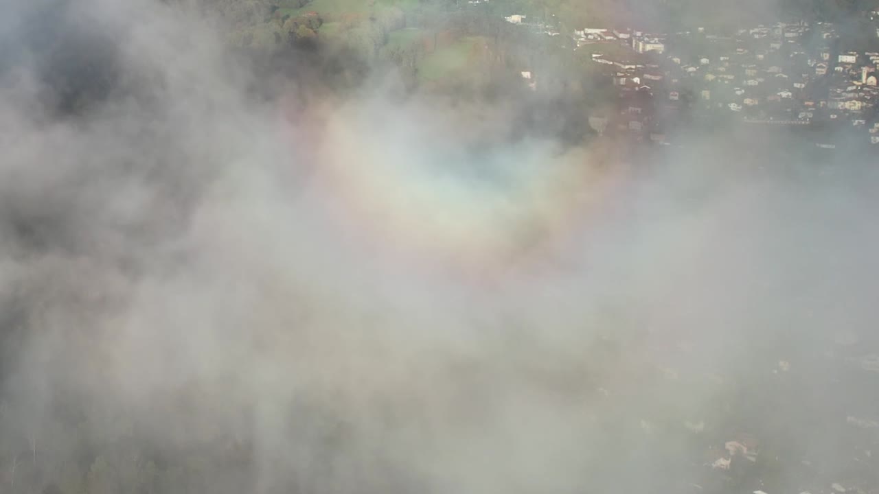 Scenic aerial view of clouds with rainbow over Italian Alps landscape