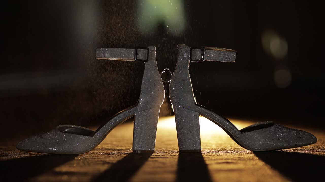 anillos de bodas colocados entre las novias zapatos de bodas salpicados con spray de perfume, cámara lenta