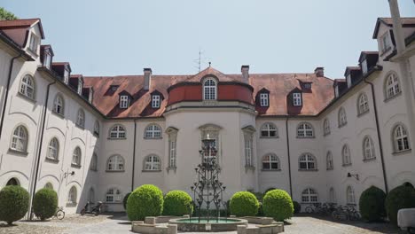 Sunny-courtyard-view-of-historical-Lindau-buildings,-Bodensee-with-fountain