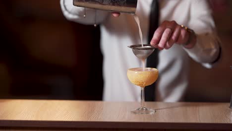 Bartender-is-straining-a-cocktail-into-a-glass