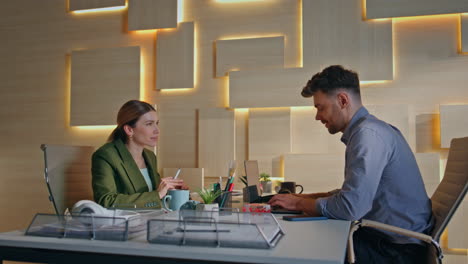 two coworkers sharing ideas in coworking space. couple smiling managers talking