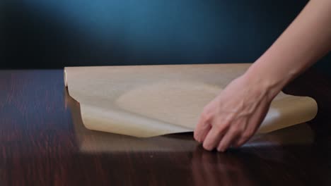 cook cutting a section of baking paper with scissors